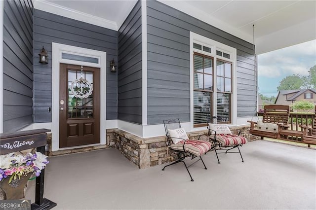 doorway to property featuring a porch and stone siding