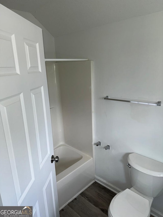 1010 Maynard St, Macon, GA 31217 - full bathroom featuring wood finished floors, baseboards, toilet, vaulted ceiling, and shower / washtub combination