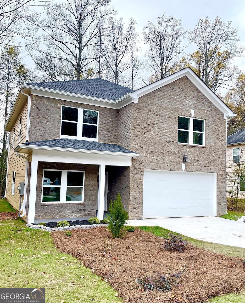 view of front of home with an attached garage, driveway, and brick siding