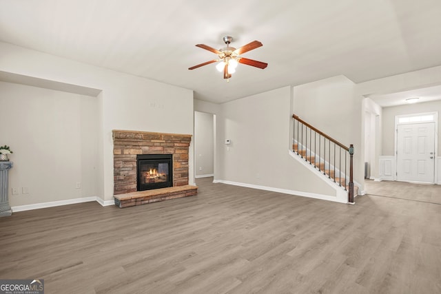 15 Manas Ct, Covington, GA 30016 - unfurnished living room with a fireplace, ceiling fan, stairs, baseboards, and wood finished floors