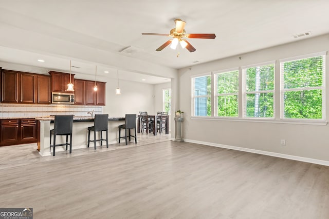 15 Manas Ct, Covington, GA 30016 - living area with baseboards, visible vents, ceiling fan, and light wood-style floors