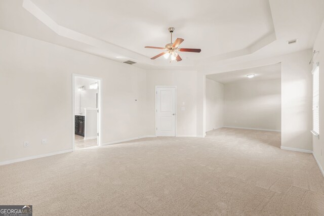 15 Manas Ct, Covington, GA 30016 - spare room featuring visible vents, ceiling fan, light carpet, and a tray ceiling