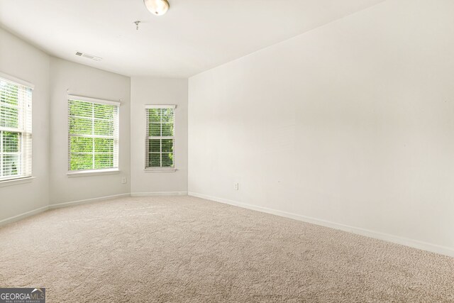 15 Manas Ct, Covington, GA 30016 - spare room featuring visible vents, light carpet, and baseboards