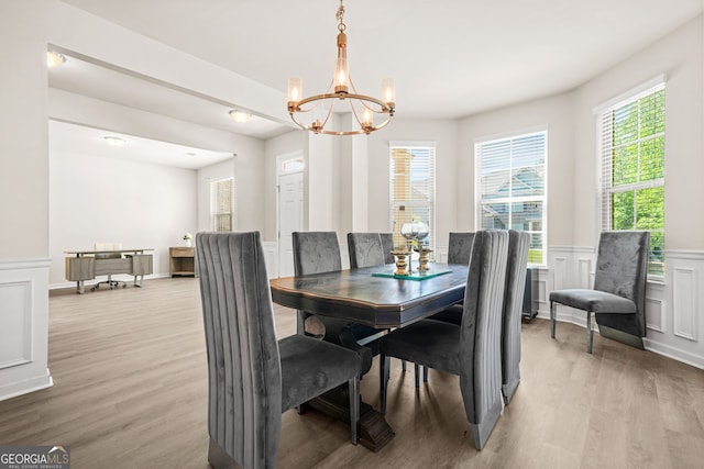 15 Manas Ct, Covington, GA 30016 - dining space featuring a wainscoted wall, wood finished floors, a notable chandelier, and a decorative wall