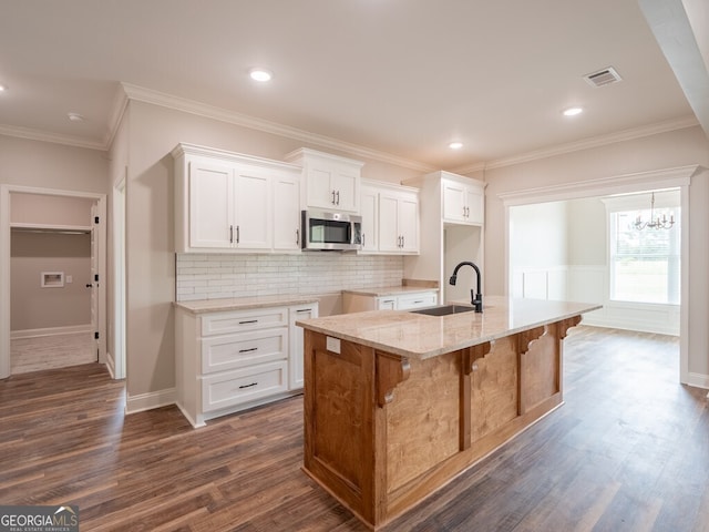 153 Lakeridge Dr, Adel, GA 31620 - kitchen featuring stainless steel microwave, a sink, visible vents, light stone countertops, and dark wood-type flooring