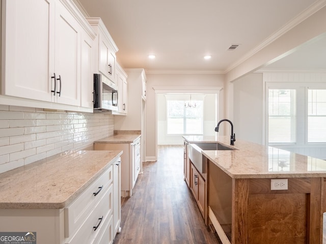 153 Lakeridge Dr, Adel, GA 31620 - kitchen with light stone counters, stainless steel microwave, a sink, visible vents, and wood finished floors