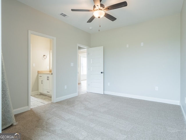153 Lakeridge Dr, Adel, GA 31620 - unfurnished bedroom featuring connected bathroom, light carpet, baseboards, visible vents, and a ceiling fan