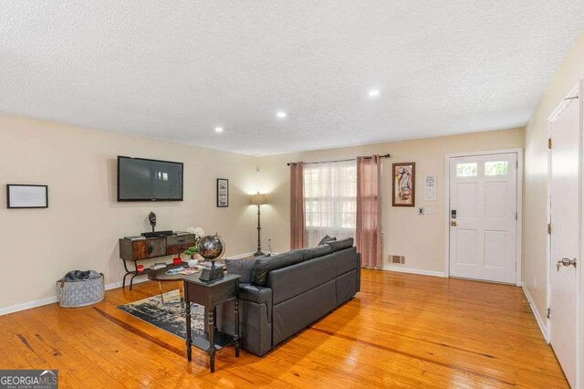 4393 Housworth Dr, Stonecrest, GA 30038 - living room featuring light wood-style floors, visible vents, a textured ceiling, and recessed lighting