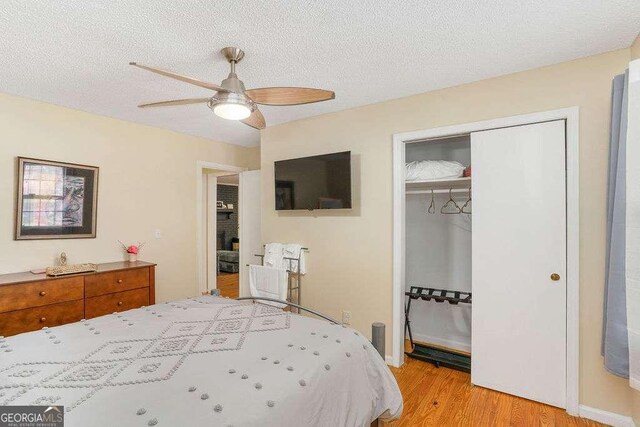 4393 Housworth Dr, Stonecrest, GA 30038 - bedroom featuring a ceiling fan, a textured ceiling, a closet, and light wood finished floors