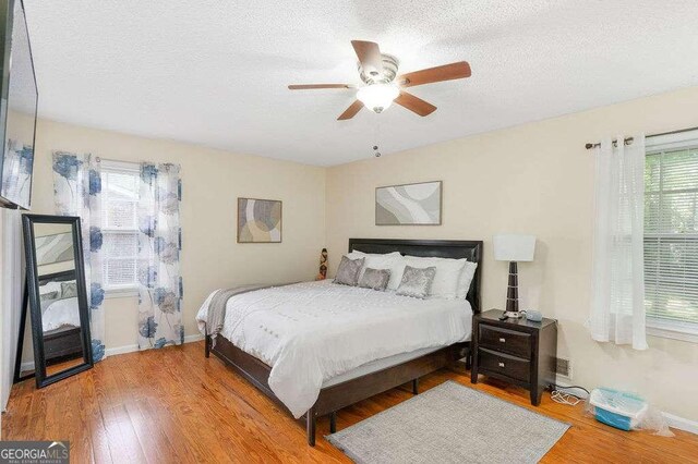 4393 Housworth Dr, Stonecrest, GA 30038 - bedroom with a textured ceiling, wood finished floors, baseboards, and multiple windows