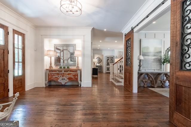 entryway featuring a chandelier, hardwood / wood-style floors, ornamental molding, and stairs
