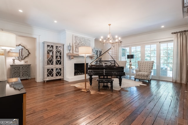 living area with crown molding, hardwood / wood-style floors, an inviting chandelier, recessed lighting, and a fireplace