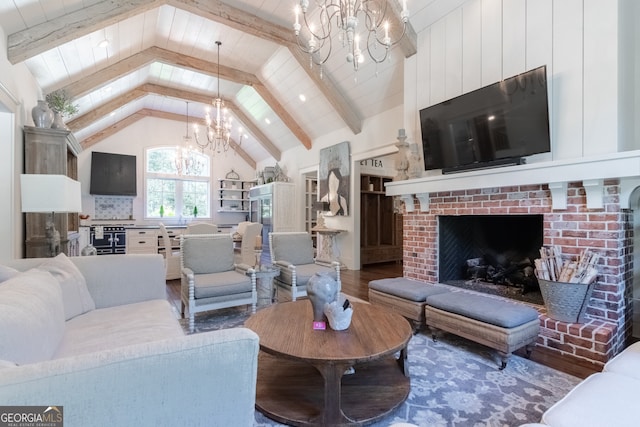 living room with lofted ceiling with beams, a notable chandelier, wood finished floors, and a fireplace