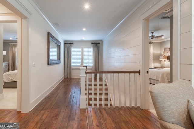 hallway with hardwood / wood-style flooring, visible vents, baseboards, recessed lighting, and ornamental molding