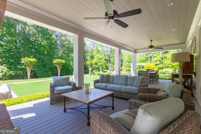 wooden terrace featuring an outdoor living space, a ceiling fan, a lawn, and outdoor dining area