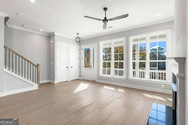 foyer with a ceiling fan, stairs, baseboards, ornamental molding, and wood finished floors
