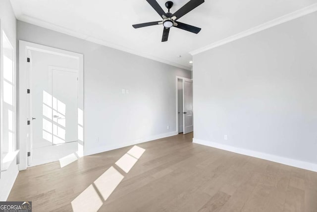 unfurnished room featuring baseboards, ornamental molding, ceiling fan, and wood finished floors