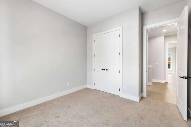 unfurnished bedroom featuring a closet, carpet flooring, and baseboards