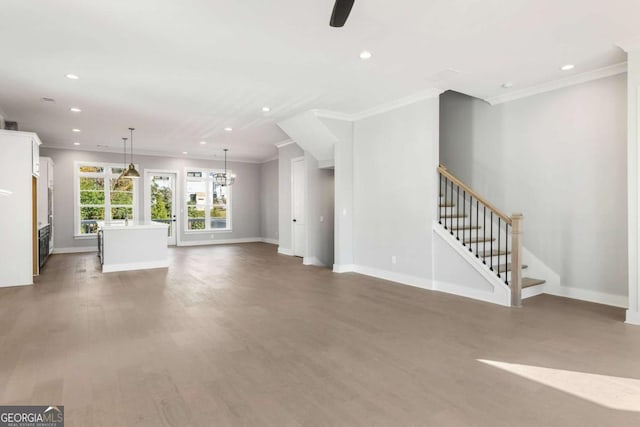unfurnished living room featuring ornamental molding, stairway, wood finished floors, and baseboards