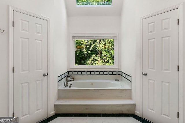 601 Ashley Forest Dr NW, Acworth, GA 30102 - bathroom featuring a garden tub, tile patterned flooring, and a skylight
