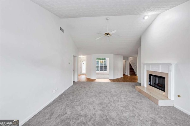 unfurnished living room featuring carpet, vaulted ceiling, ceiling fan, baseboards, and visible vents
