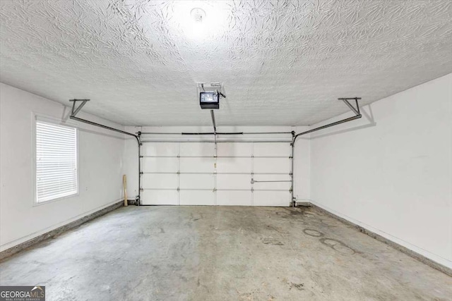 garage featuring a garage door opener and baseboards