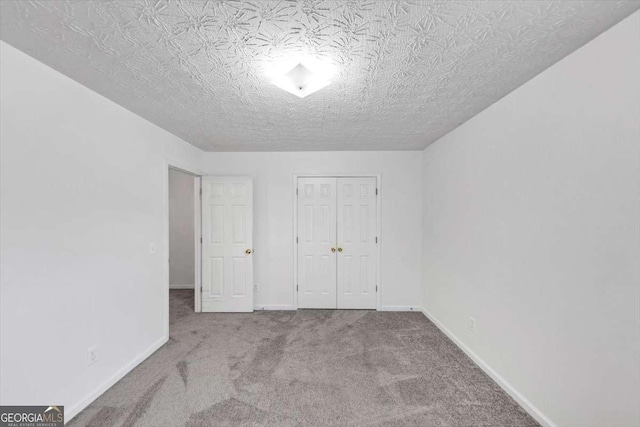 unfurnished bedroom with baseboards, a closet, and carpet