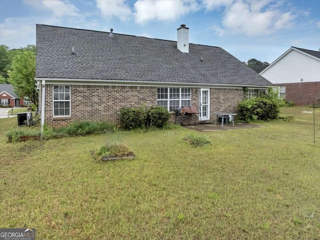 back of house featuring a yard, a shingled roof, a chimney, and brick siding