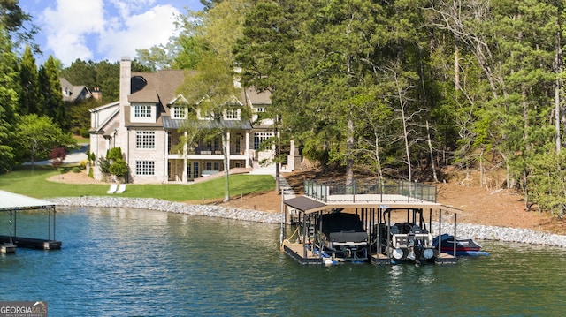view of dock with a lawn, a water view, and boat lift