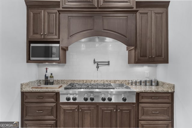 bar with stainless steel appliances and decorative backsplash