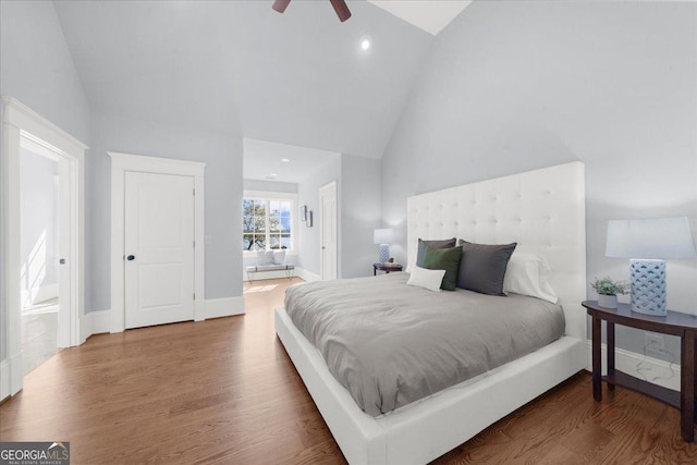 bedroom featuring recessed lighting, high vaulted ceiling, wood finished floors, and ensuite bathroom