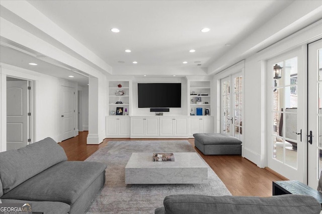 living area featuring recessed lighting, built in features, and wood finished floors