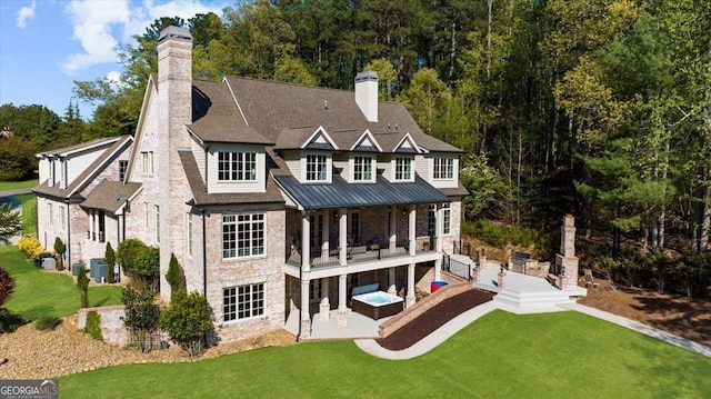 rear view of house with a patio, a yard, central AC, and a chimney