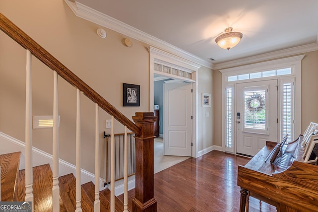 foyer entrance with visible vents, baseboards, ornamental molding, dark wood-type flooring, and stairs