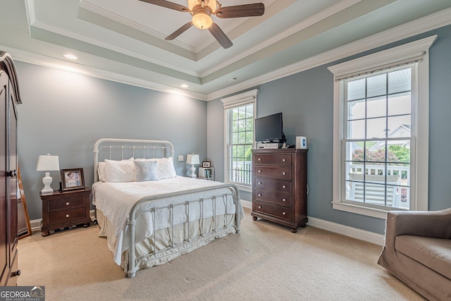 bedroom with a raised ceiling, baseboards, ornamental molding, light carpet, and a ceiling fan