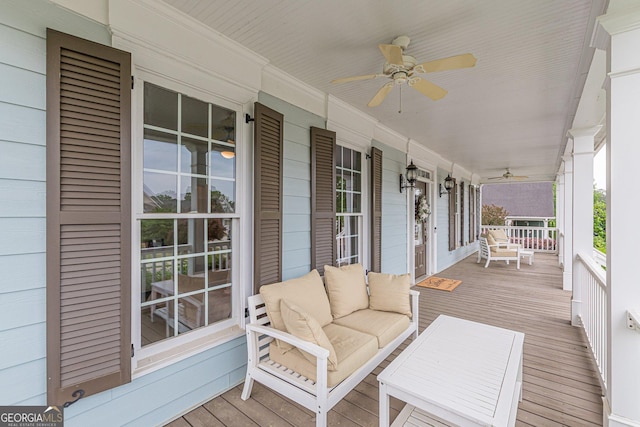 wooden deck featuring covered porch and a ceiling fan
