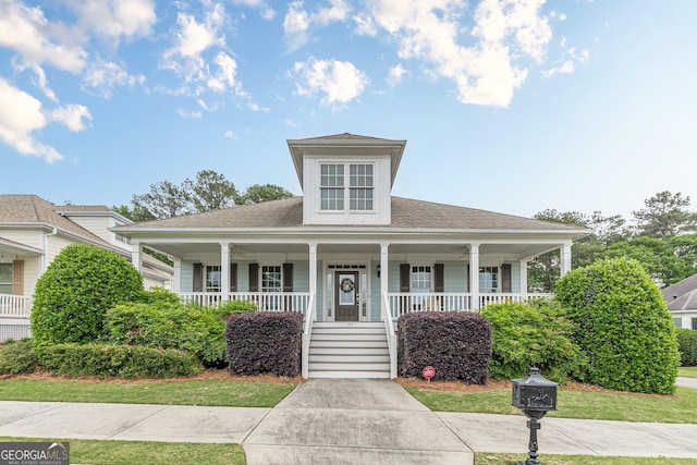 view of front of home featuring covered porch and a shingled roof