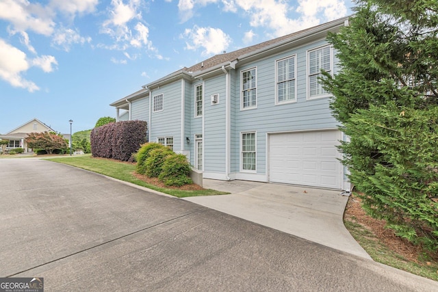 view of side of home featuring a garage and concrete driveway