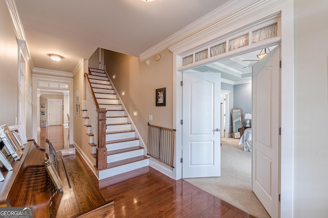staircase with baseboards, ornamental molding, and wood-type flooring
