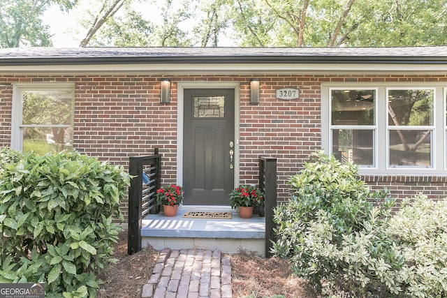 doorway to property with brick siding