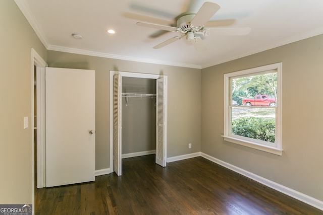 unfurnished bedroom with baseboards, ornamental molding, dark wood-style floors, and a closet