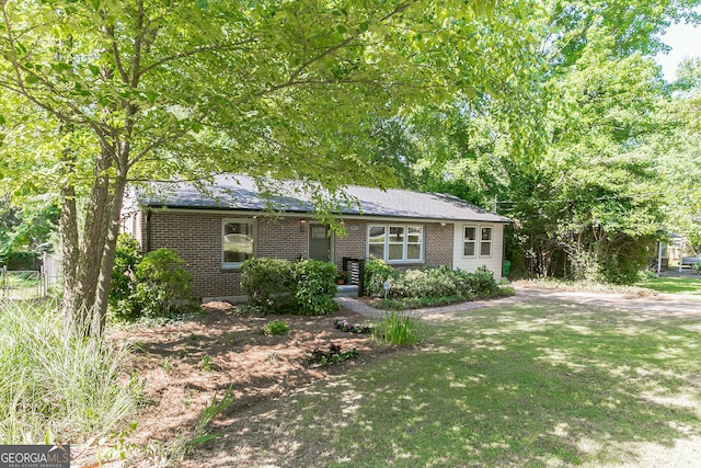 ranch-style home with a front yard and brick siding