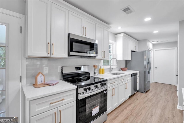 3951 Lindley Dr, Powder Springs, GA 30127 - kitchen with stainless steel appliances, a sink, white cabinets, backsplash, and recessed lighting