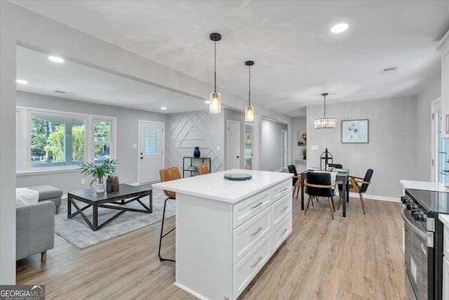 3951 Lindley Dr, Powder Springs, GA 30127 - kitchen featuring electric stove, a breakfast bar, white cabinetry, baseboards, and light wood-style flooring