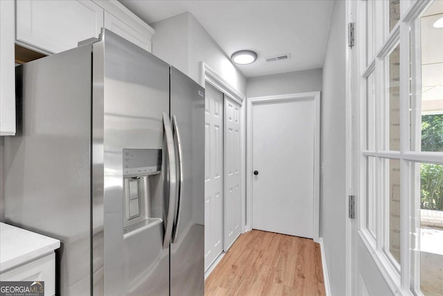 3951 Lindley Dr, Powder Springs, GA 30127 - kitchen featuring stainless steel fridge with ice dispenser, light wood-style floors, and white cabinets