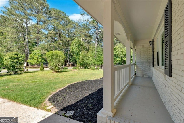 3951 Lindley Dr, Powder Springs, GA 30127 - view of green lawn with covered porch and view of scattered trees