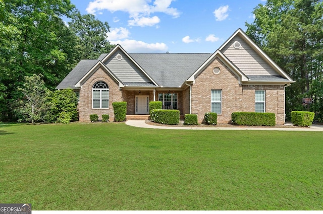 craftsman-style home with a front yard and brick siding