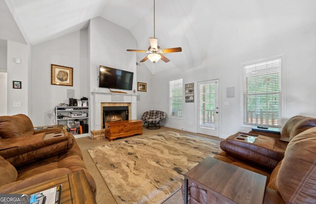 bedroom with light carpet, multiple windows, ceiling fan, and a tray ceiling