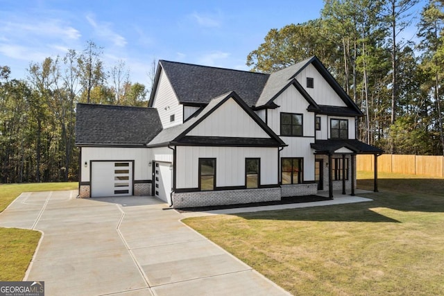 modern inspired farmhouse with fence, driveway, roof with shingles, a front lawn, and an attached garage