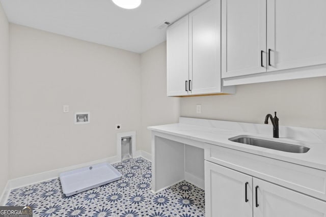 washroom with a sink, cabinet space, electric dryer hookup, hookup for a washing machine, and baseboards